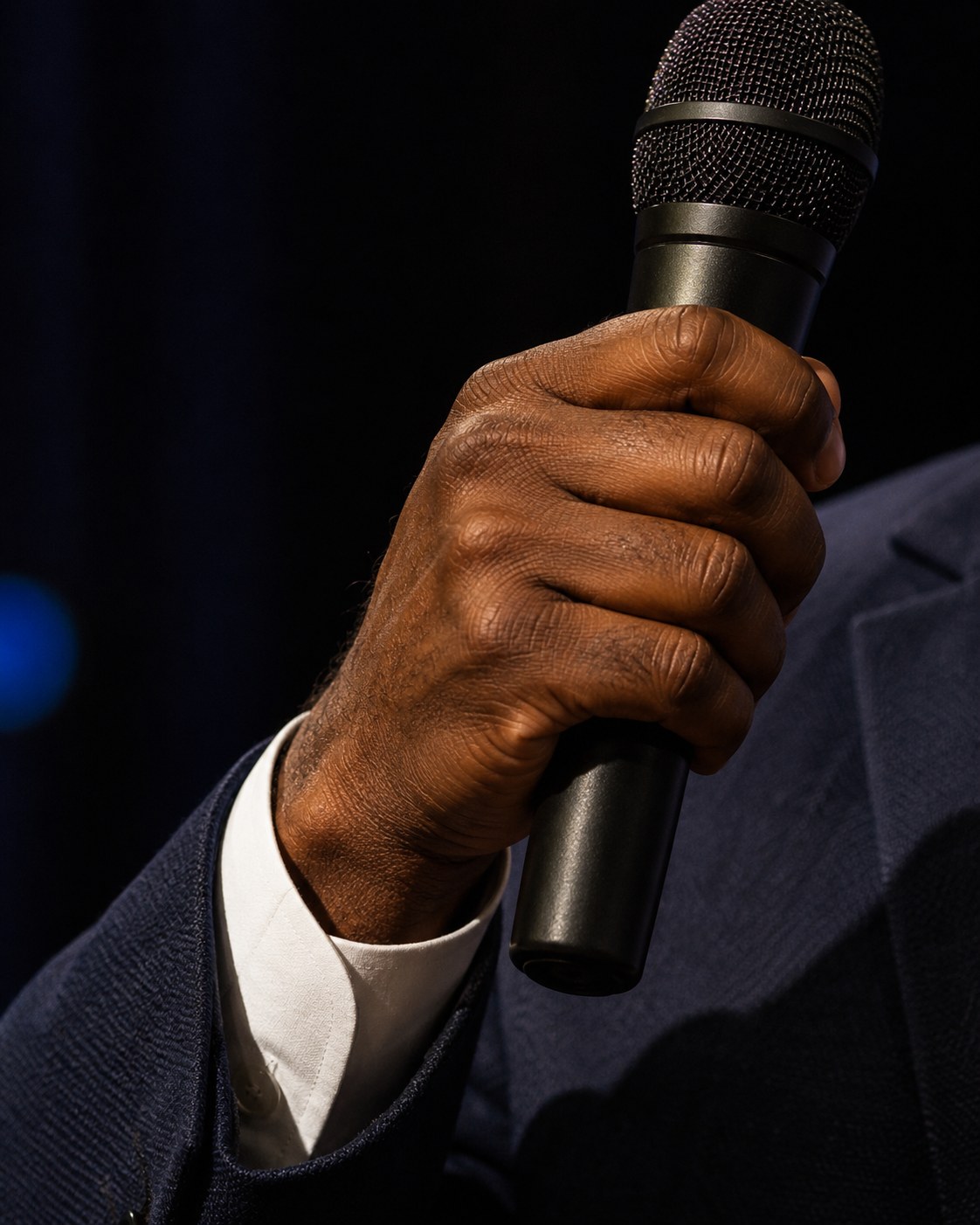 Close crop of a hand gripping a microphone